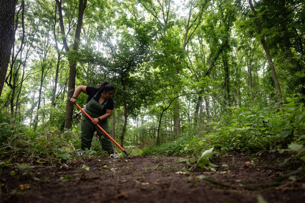 woman in overalls doing trail work