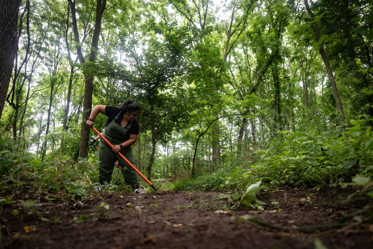 woman in overalls doing trail work