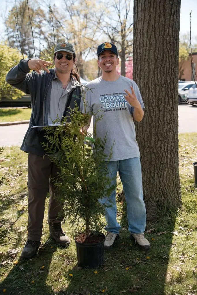 two men smiling by a container tree