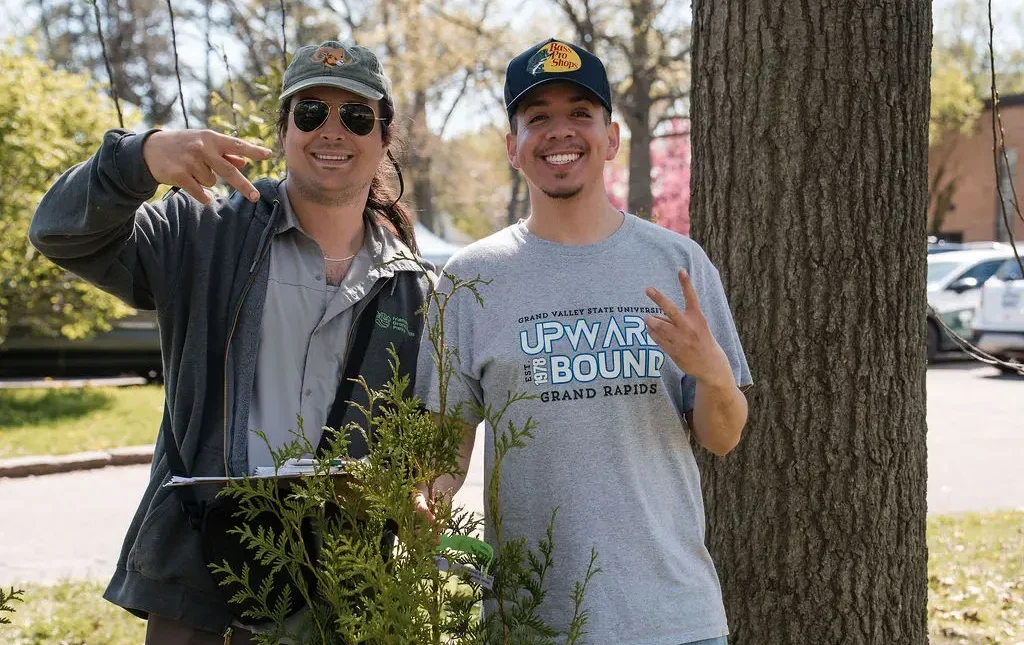 two men smiling by a container tree