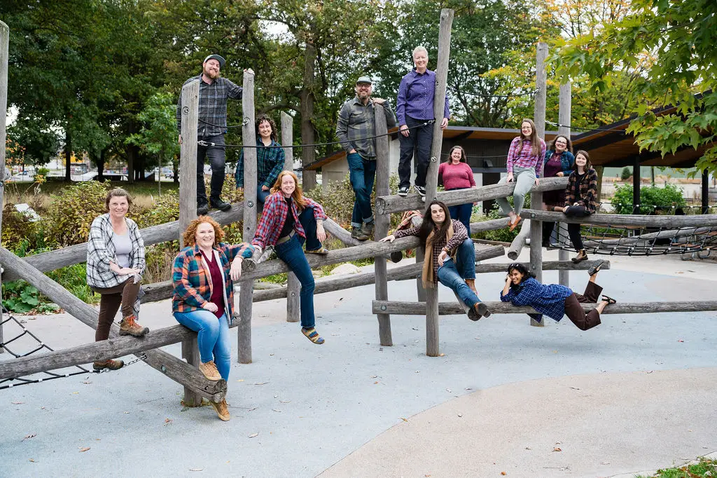 group of people sitting on wooden play structure and smiling